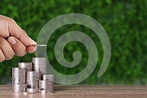 Business investment and saving growth for advertising concept. Businessman hand stacking coin growing on wood table and green