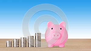 Business investment and saving growth for advertising concept. Stacking coin growing with pink piggy bank on blue background,