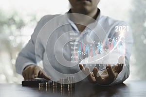 Business investor holding virtual stock market chart and using calculator  to analysis , business analyse by use technology