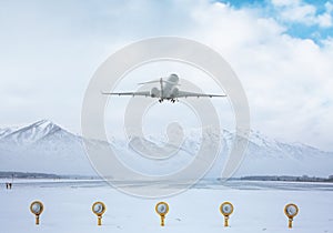 Business jet take off from airport runway against the backdrop of scenic snow-capped mountains