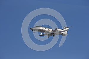 Business jet taking off isolated on a blue sky background.