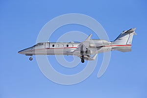 Business jet taking off isolated on a blue sky background.