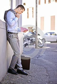 Business, job loss and man on street, fired and reading letter of unemployment on city sidewalk. Anxiety, mental health