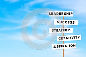 Business keywords on road sign blue sky background. leadership success concept