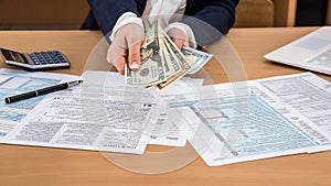 Business lady counts dollars, the tax form 1040