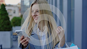 Business lady Going from Shopping, Walking with Paper Bags and Scrolling Texting on Smartphone. Charming Woman Using