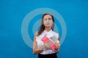 Business lady in handcuffs holding an envelope with dollars