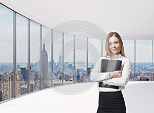Business lady is holding a black document case. New York panoramic office. A concept of legal services.