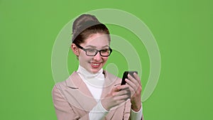 Business lady looks at photos on her smartphone. Green screen