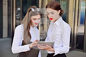 Business lady. Office staff. Two young girls with electronic tab photo