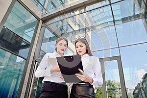 Business lady. Office staff. Two young girls with electronic tab photo