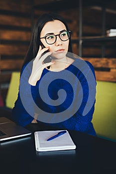 Business lady speak on phone and make notes at work table