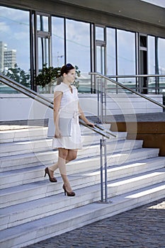 Business lady walking stairs with mobile phone lap