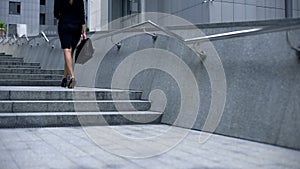 Business lady walking upstairs and texting on smartphone, careerist lifestyle