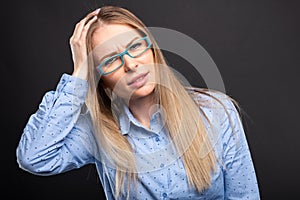 Business lady wearing blue glasses holding head like hurting