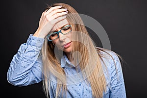 Business lady wearing blue glasses holding head like hurting