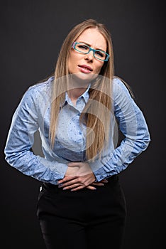 Business lady wearing blue glasses holding stomach like hurting