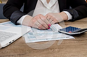 Business lady works with a 1040 form and a laptop