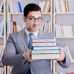 The business law student with pile of books working in library