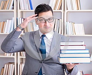 Business law student with pile of books working in library