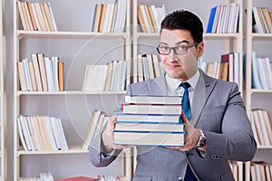 The business law student with pile of books working in library