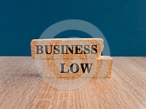 Business law symbol. Concept words Business law on beautiful brick blocs. Beautiful blue background, wooden table. Legal concept