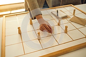 Business leader choosing wooden people from a group of employees on a planning board