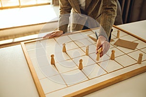 Business leader choosing wooden people from a group of employees on a planning board