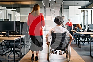 A business leader with her colleague, an African-American businessman who is a disabled person, pass by their colleagues