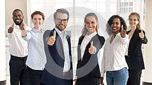 Business leaders with employees showing thumbs up looking at camera photo