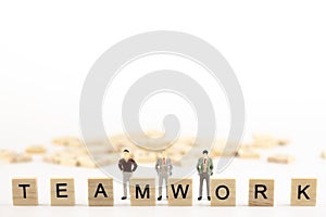 Business leadership, Teamwork power and confidence concept. Miniature people small figure standing back a wooden cube