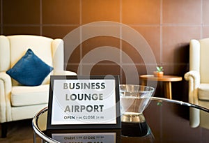 The Business Lounge Airport service time sign is placed on a modern round tempered glass table