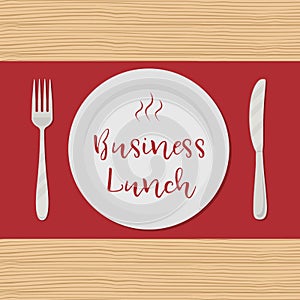 Business lunch concept. Plate with the red text `Business Lunch` on a wooden background