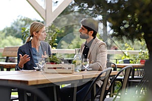 Business lunch for two managers, discussing new business project. Couple sitting outdoors on terrace restaurant, having