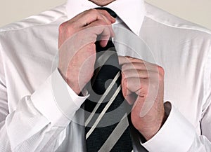 Business man adjusting tie