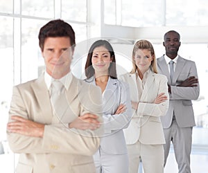 Business man with arms folded with Business Team