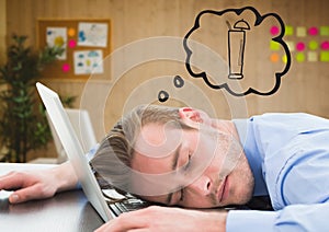 Business man asleep at laptop dreaming of cocktail against blurry office