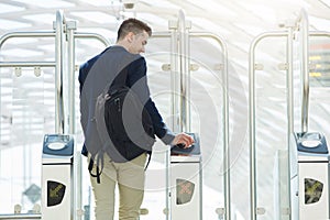 Business man at automated turnstile with cellphone