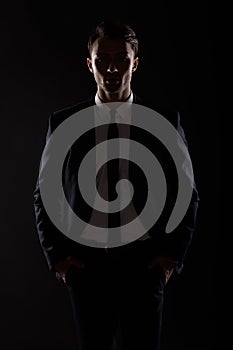 Business man in black suite, backlight