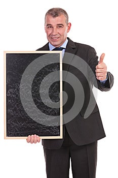 Business man with blackboard shows thumb up