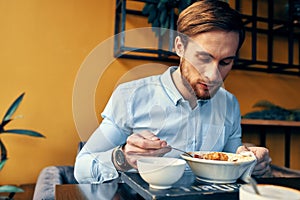 business man in blue shirt having lunch at a cafe table