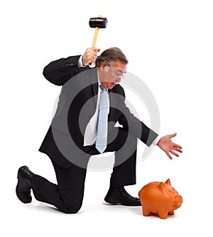 Business man breaking piggy bank