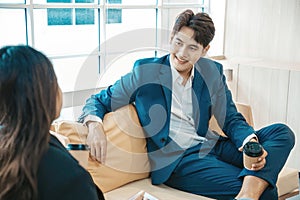 Business man and business woman sitting together with a cup of coffee.
