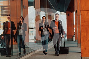 Business man and business woman talking and holding luggage traveling on a business trip, carrying fresh coffee in their