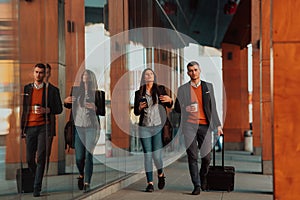 Business man and business woman talking and holding luggage traveling on a business trip, carrying fresh coffee in their