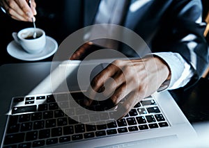 Business man in a cafe at the table in front of a laptop work a cup of coffee at the table communication technology