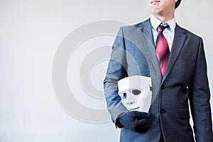 Business man carrying white mask to his body indicating Business