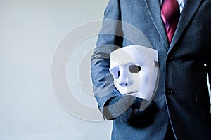 Business man carrying white mask to his body indicating Business fraud and faking business partnership photo