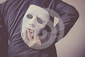 Business man carrying white mask to his body indicating Business fraud and faking business partnership photo