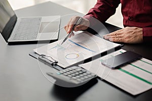 Business man checking financial documents, he owns a startup company.